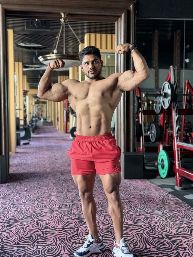 Coach Swapnil Ajagekar hitting a front double biceps pose